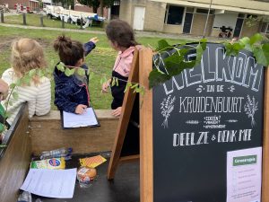 Kinderen uit het Lepelkruidhof vullen een ideeënformulier in over het opknappen van de Kruidenbuurt